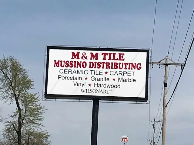 Roadside pylon sign reading M and M Tile, Mussino Distributing, ceramic tile, carpet, porcelain, granite, marble, vinyl, hardwood, Wilsonart