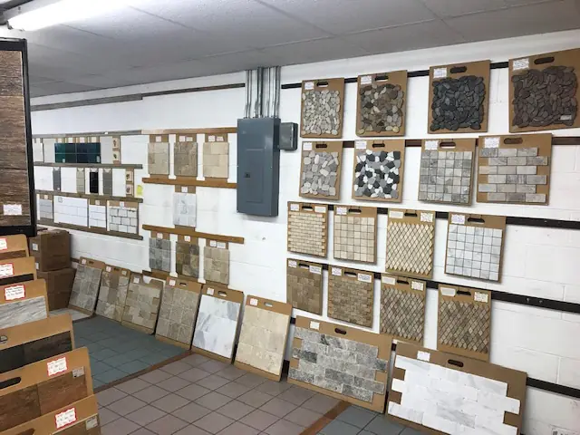 Wall of mosaic and stone sample boards in the showroom