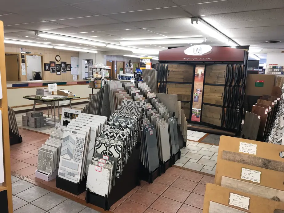 M & M showroom floor with angled racks of porcelain, patterned and subway tile boards beside a hardwood display